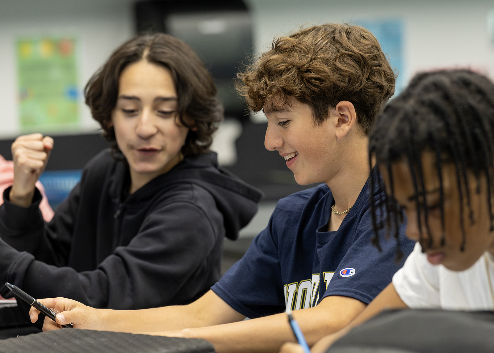 middle school students smile about solving a worksheet problem