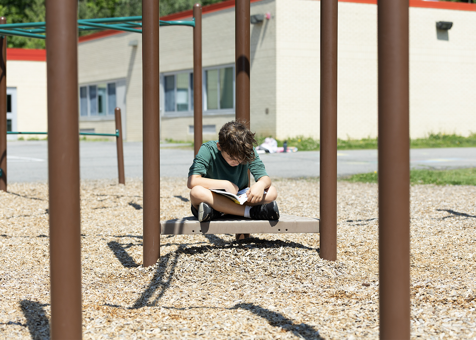 student on playground reading