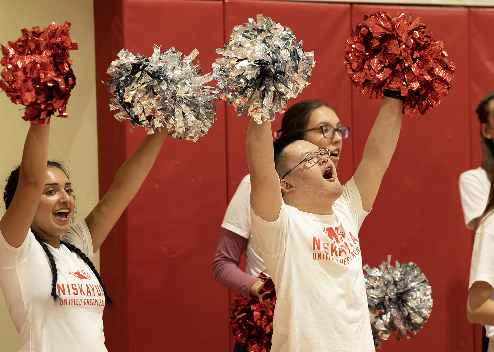 unified cheerleaders with pom poms cheering