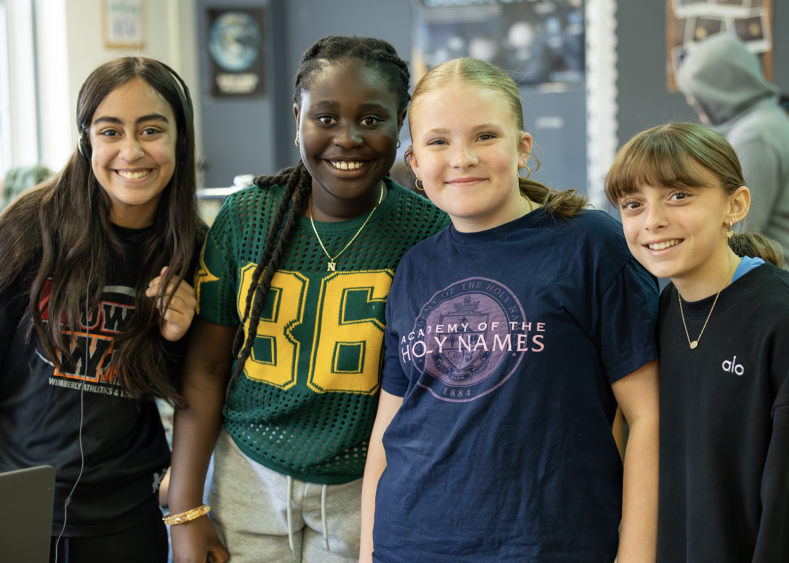 group of four middle schoolers smiling at camera