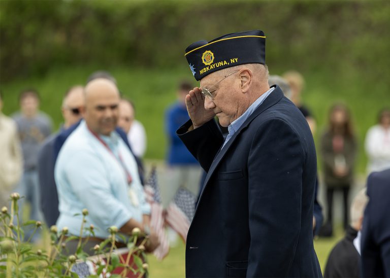 verteran saluting at memorial day ceremony