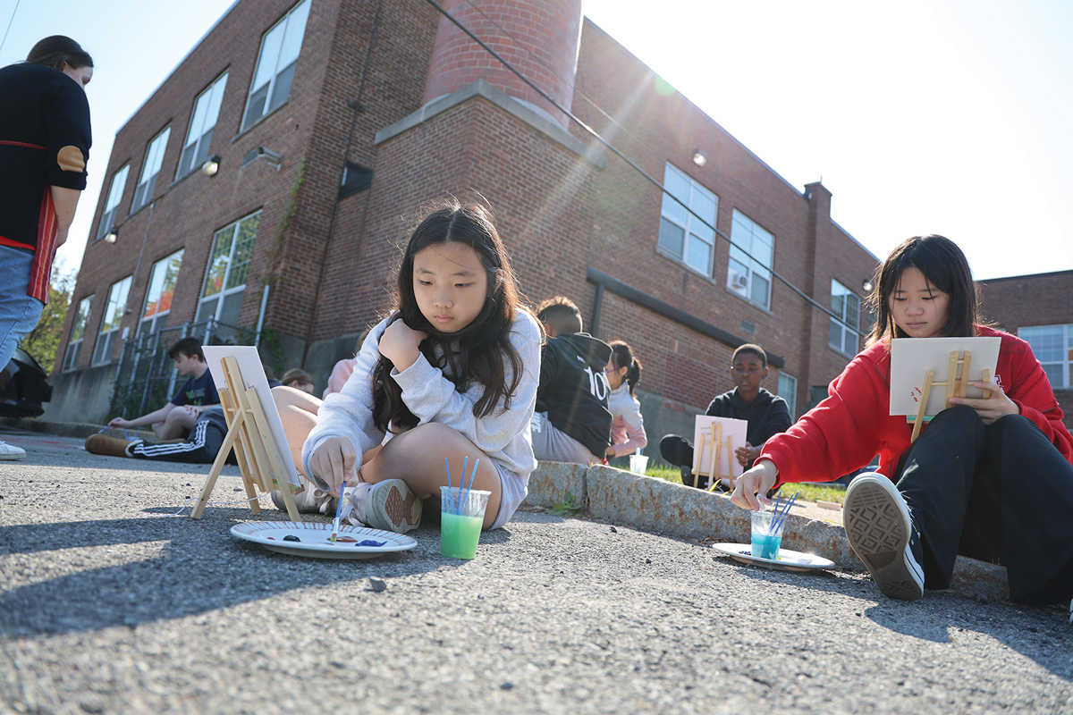 Students painting with easels outside.