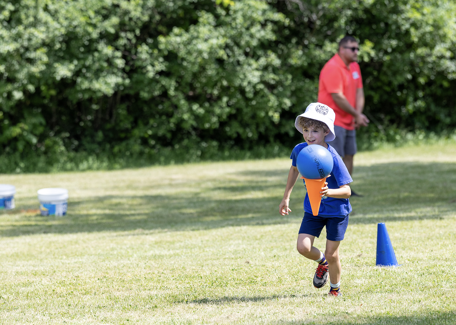 elementary student carrying ball in cone at field day