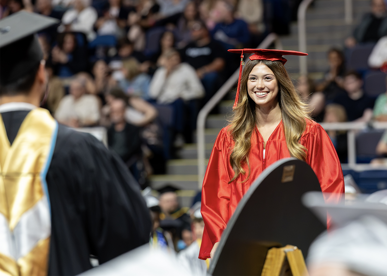 graduate walking across stage smiling