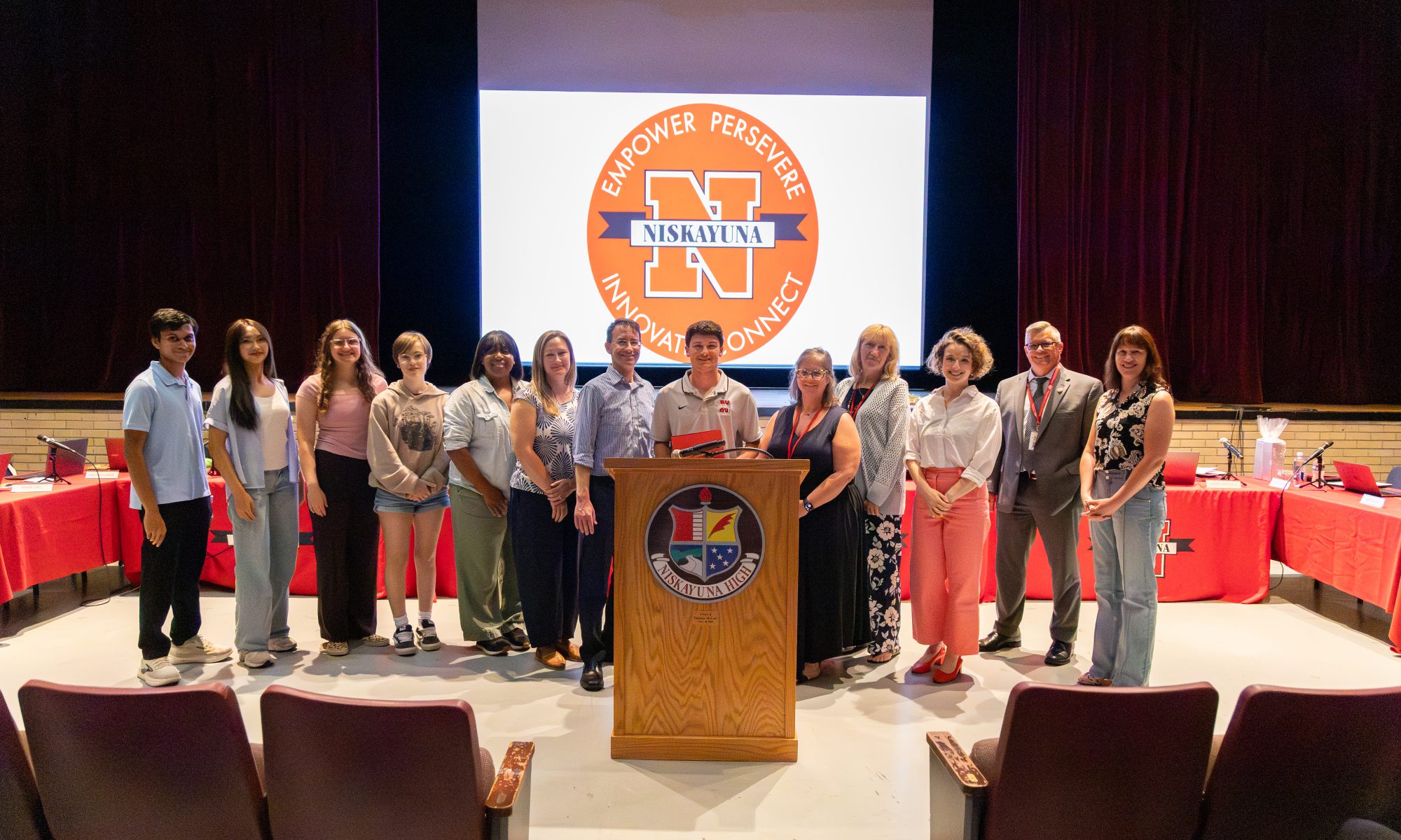 Boys lacrosse captain holds certificate with board of education members