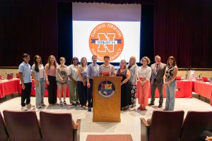 Boys lacrosse captain holds certificate with board of education members