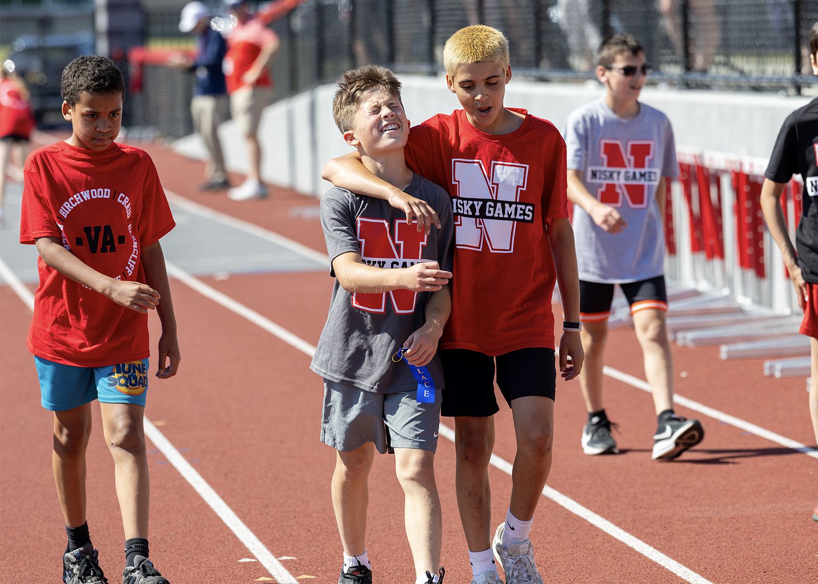 fifth grade runners react at end of race with one arm around each other