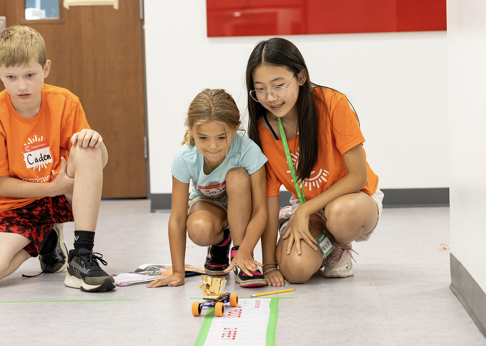 middle school and elementary schooler test a built car at camp invention