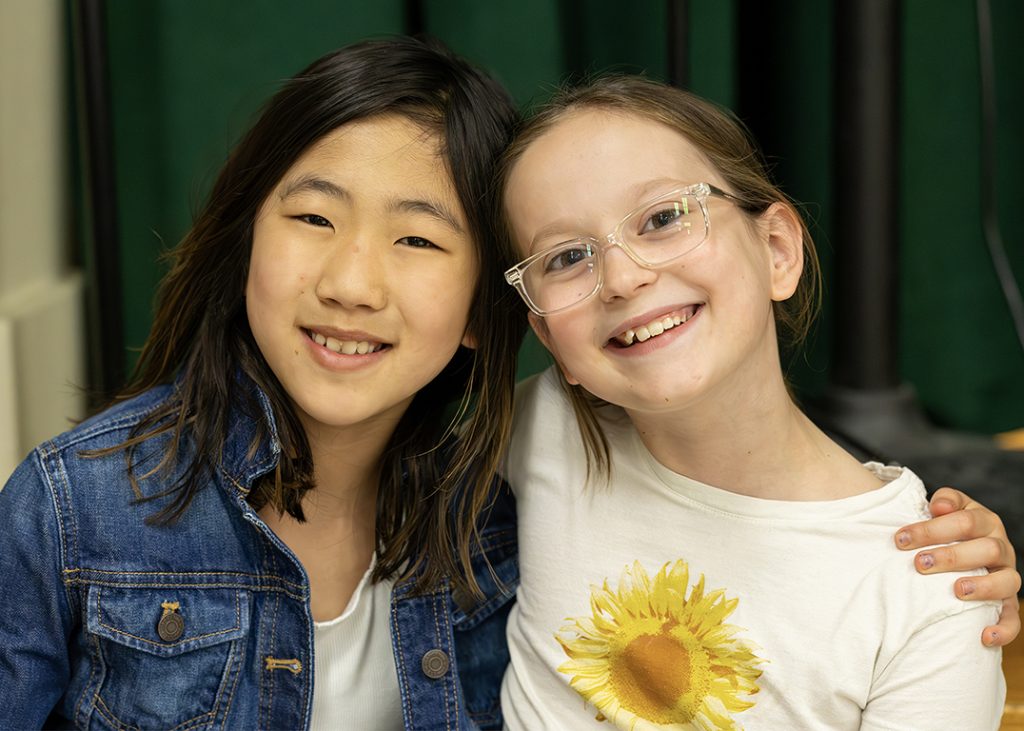 Two elementary students pose together happily.