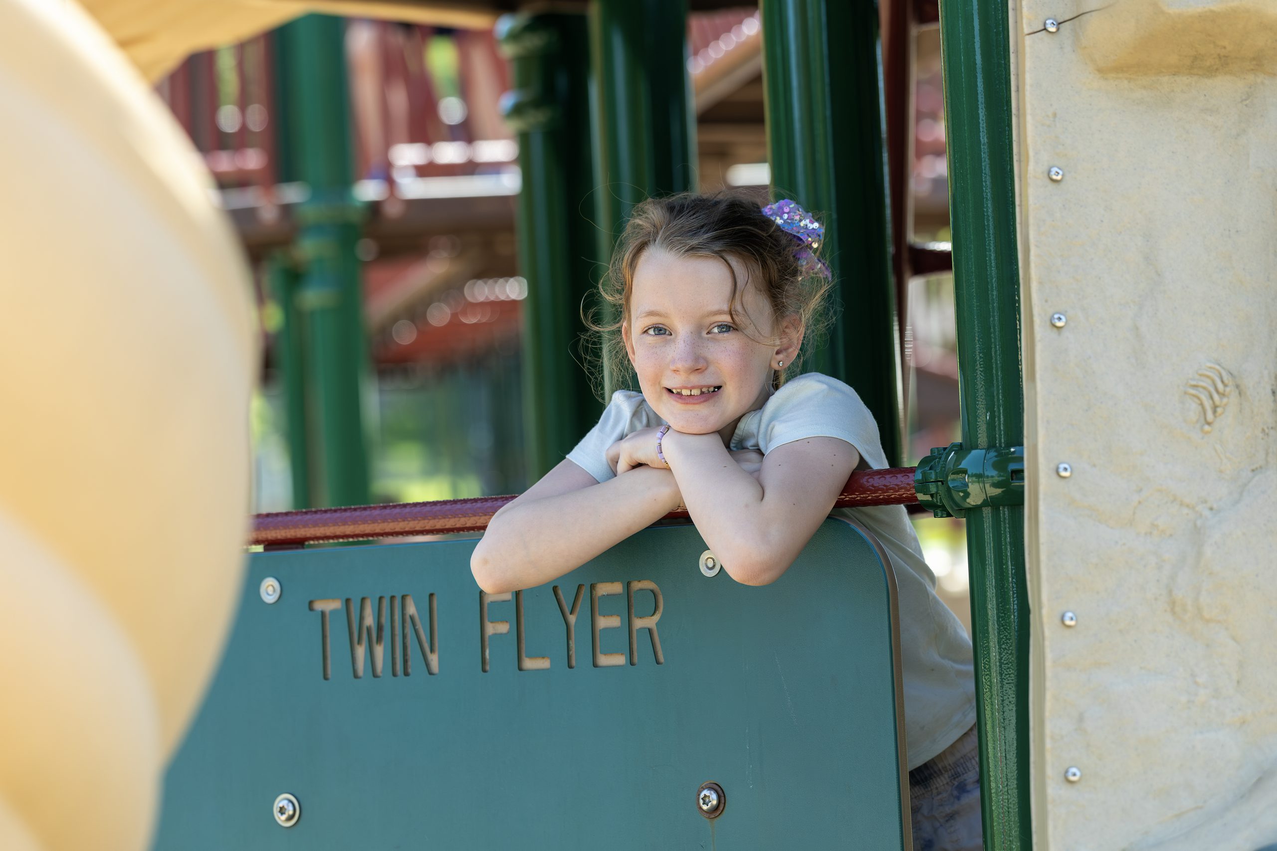 A student happily posing on the playground.