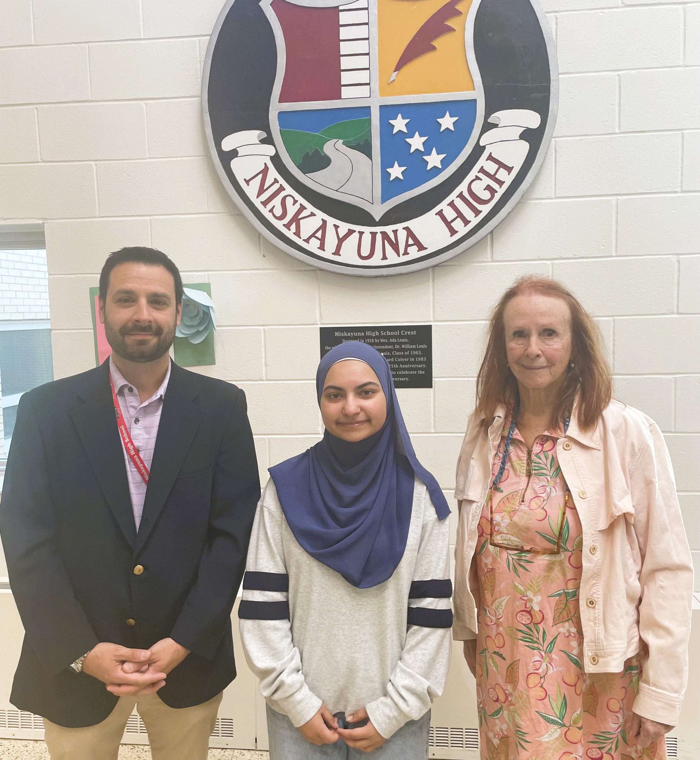 Ayesha Afghan poses for photo with two staff members.