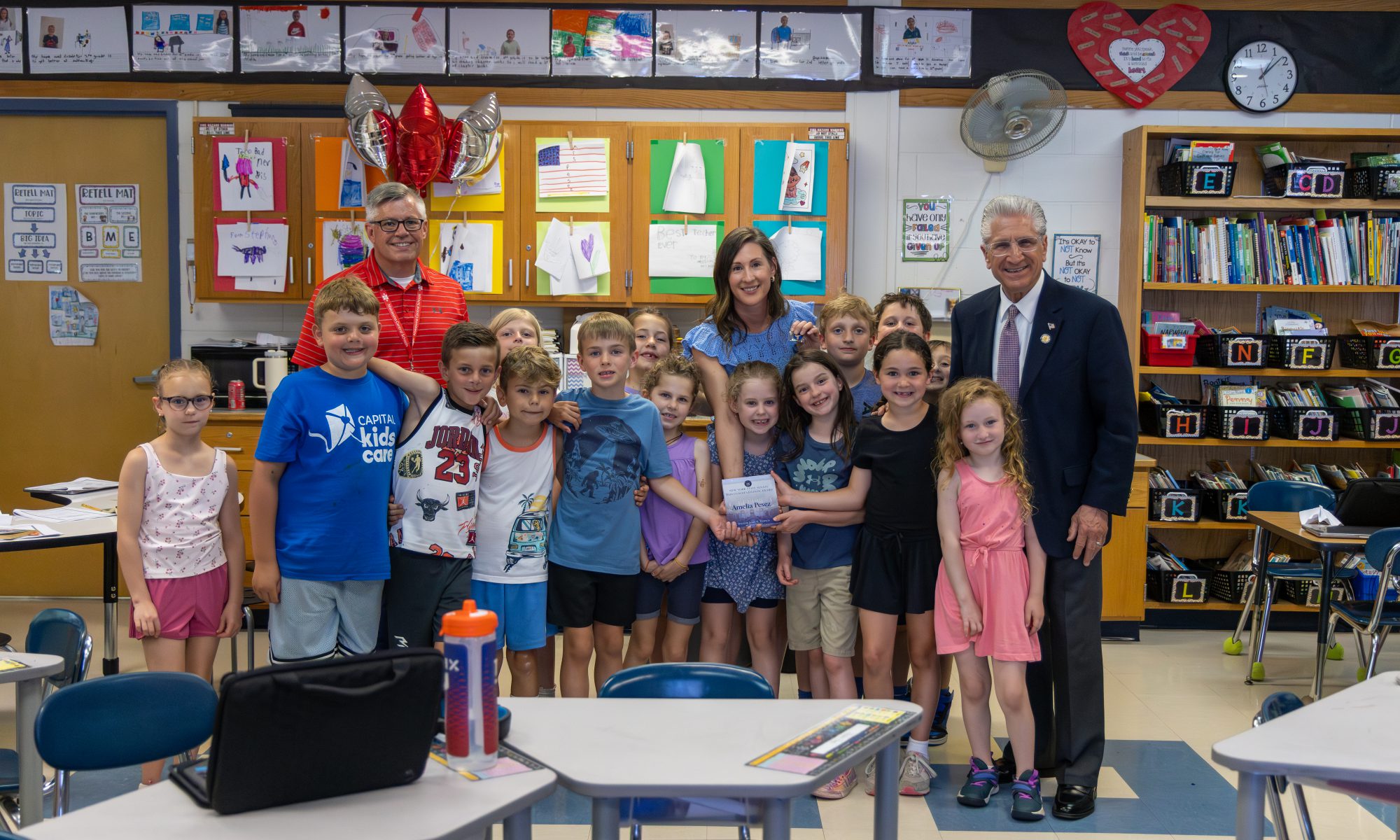 Teacher, students, superintendent, and state senator posing with commendation award