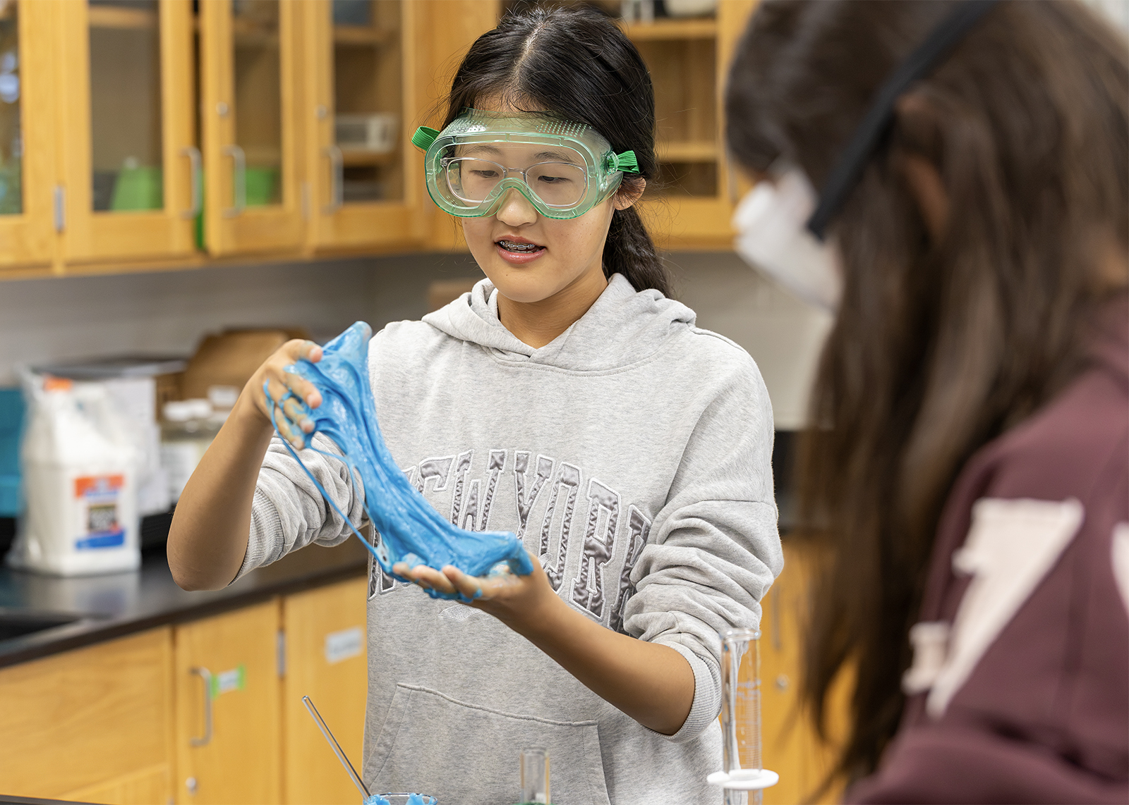 middle school student soing polyner experiment wearing goggles