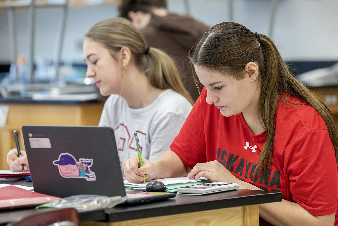 Two high school studies working in a classroom setting.