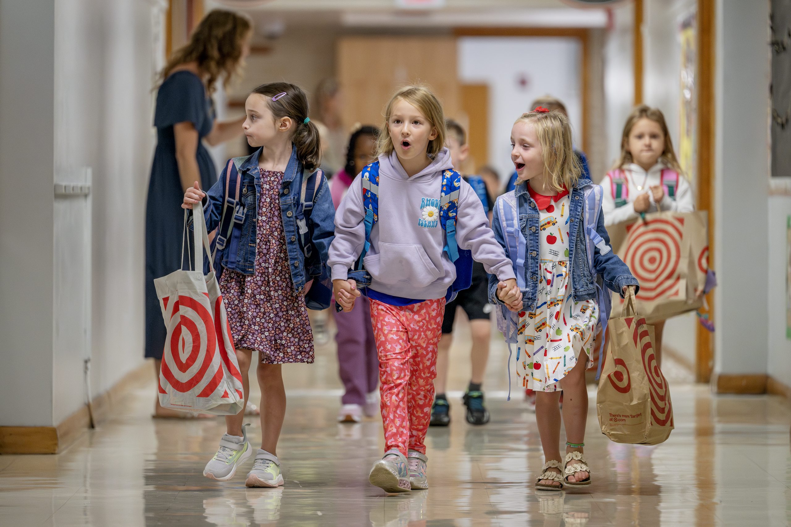 Three elementary students walk through the hallways excitedly.
