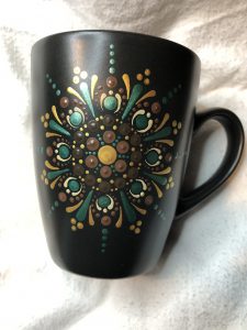 Black mug with colorful Mandala design.