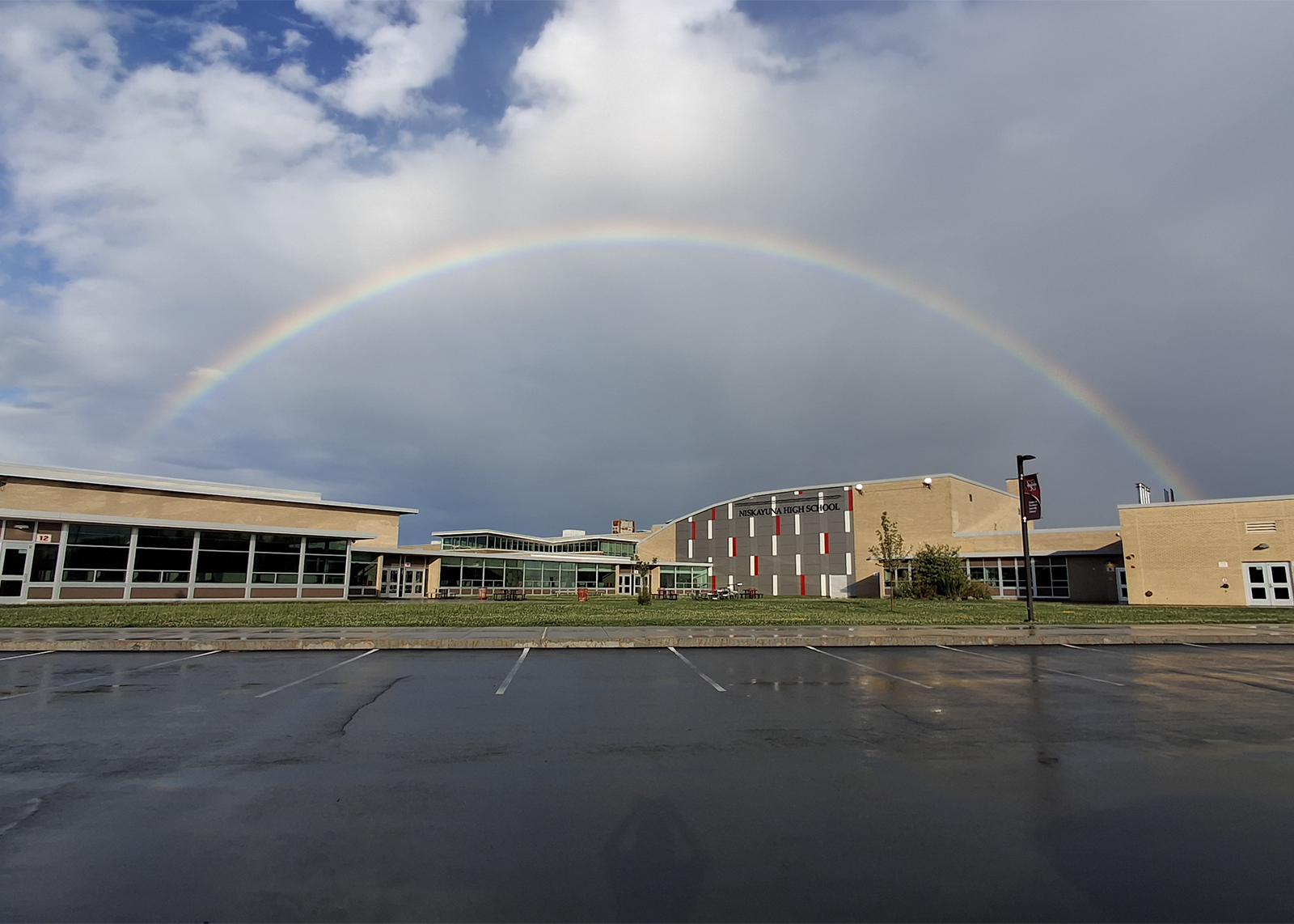 rainbow over the highschool with cloudy skies