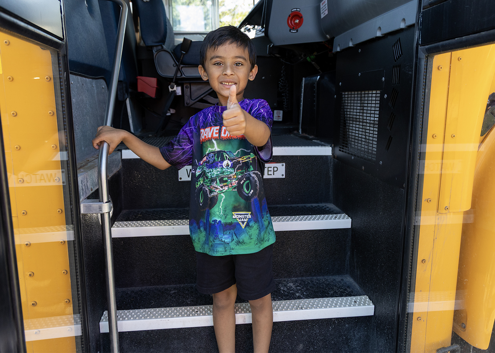 kindergartner gives thumbs up after taking practice bus ride