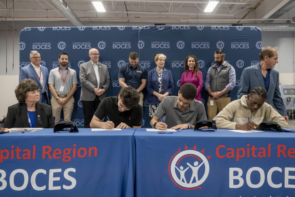 two students holding CTE signing day certificates at a a ceremony table