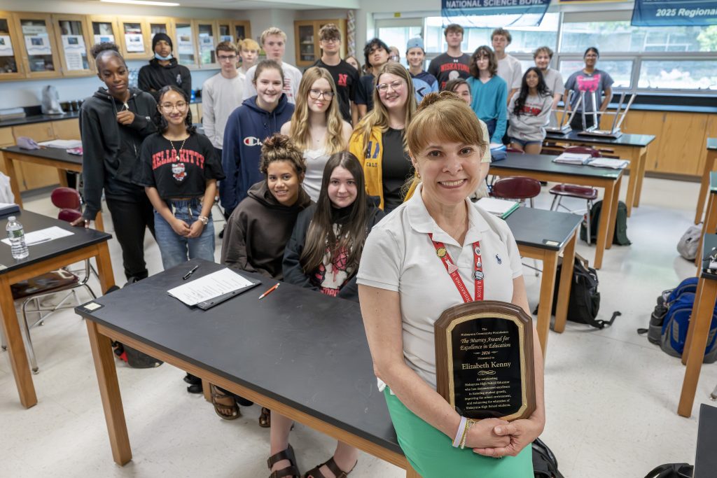 Elizabeth Kenny holding her award with her students.