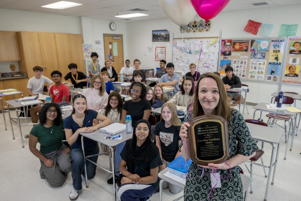 Caroline Gardner holding her award with her students.