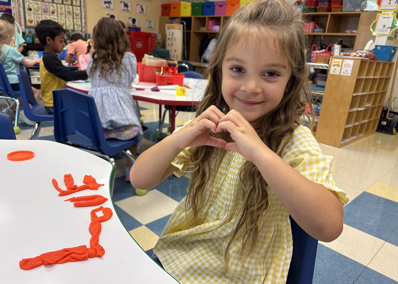 elementary student making a hand heart