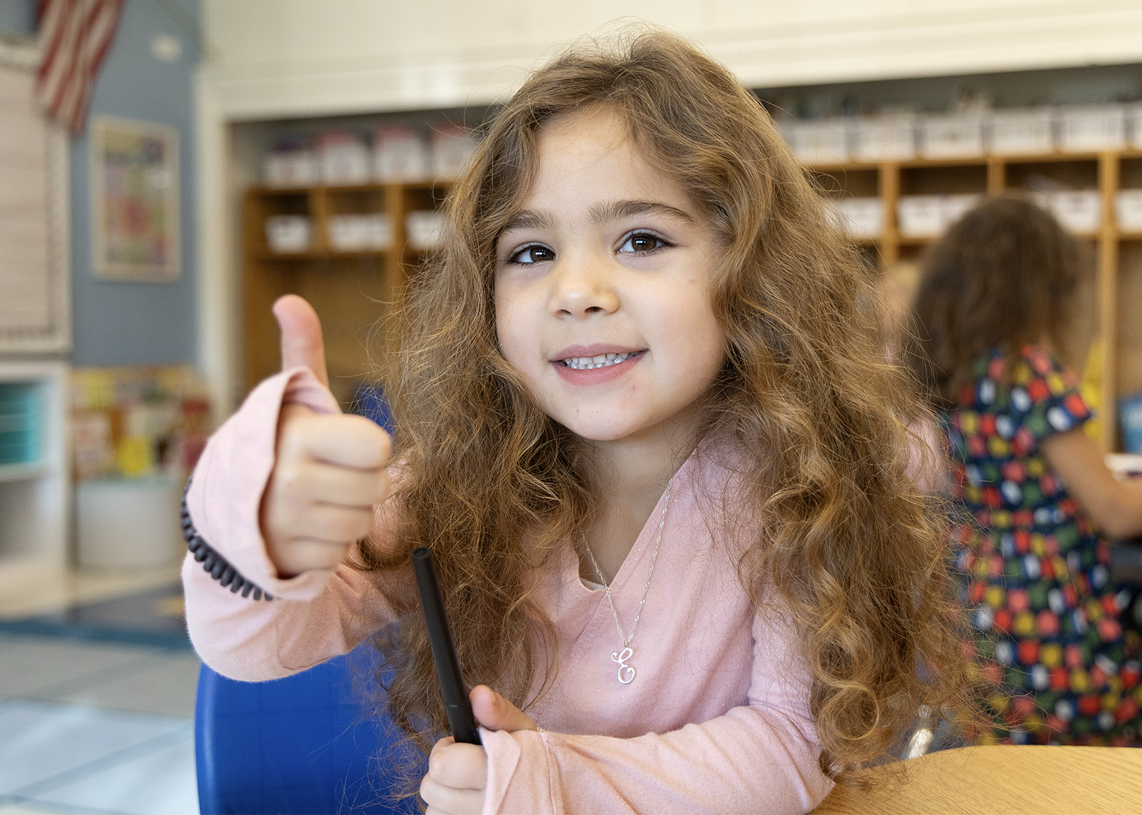 elemnetary student smiling and giving a thumbs up