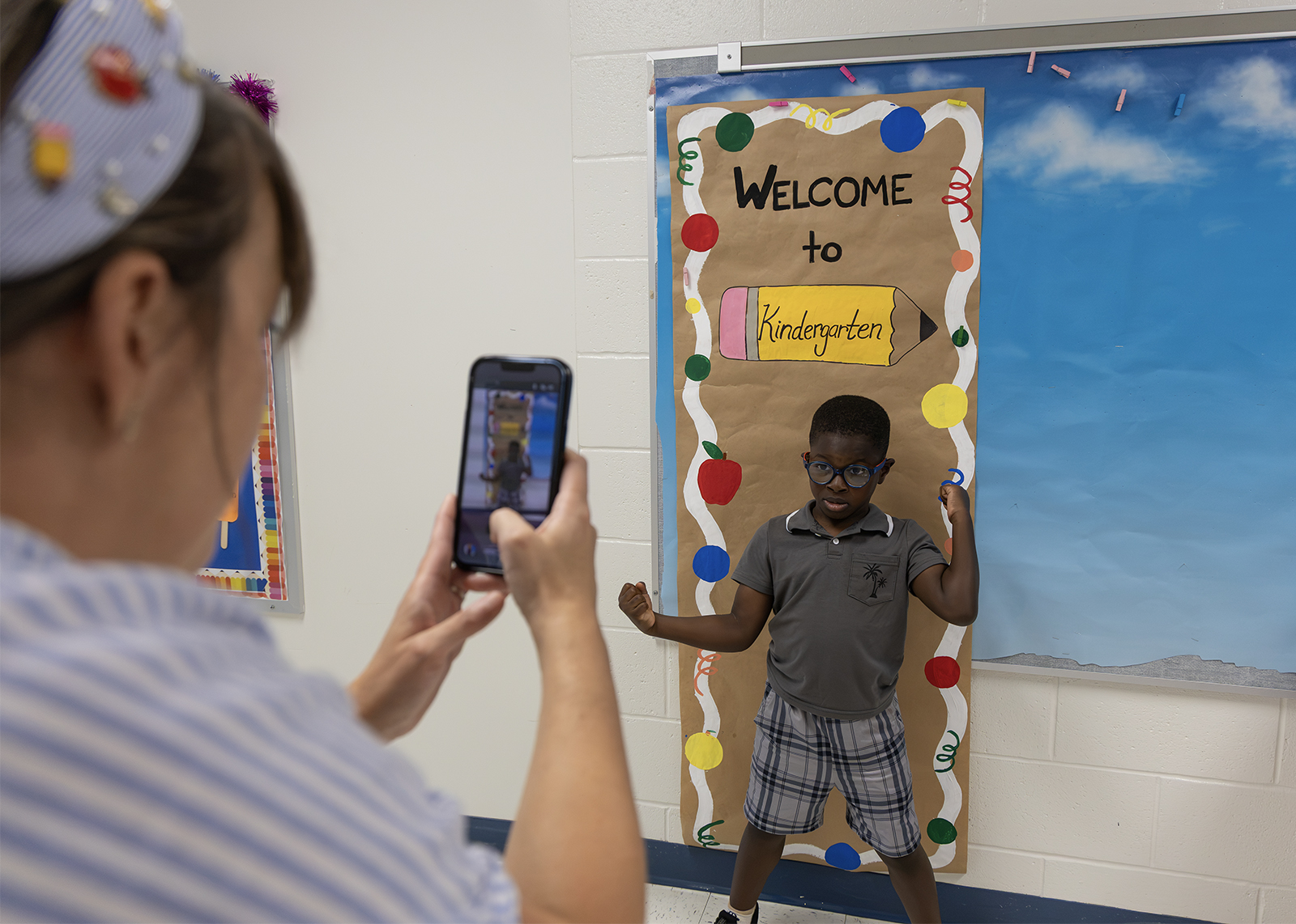 teacher takes photo of an elementary student in hallway