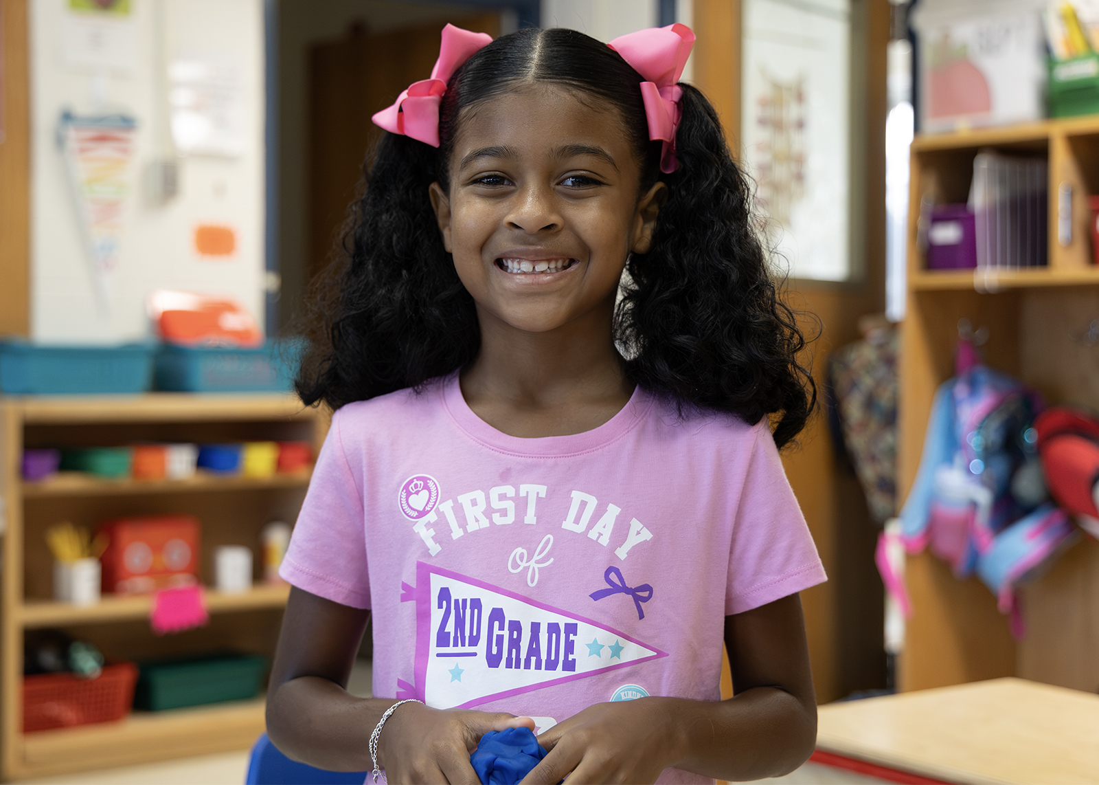 student smiles with a shirt that says first day of second grade