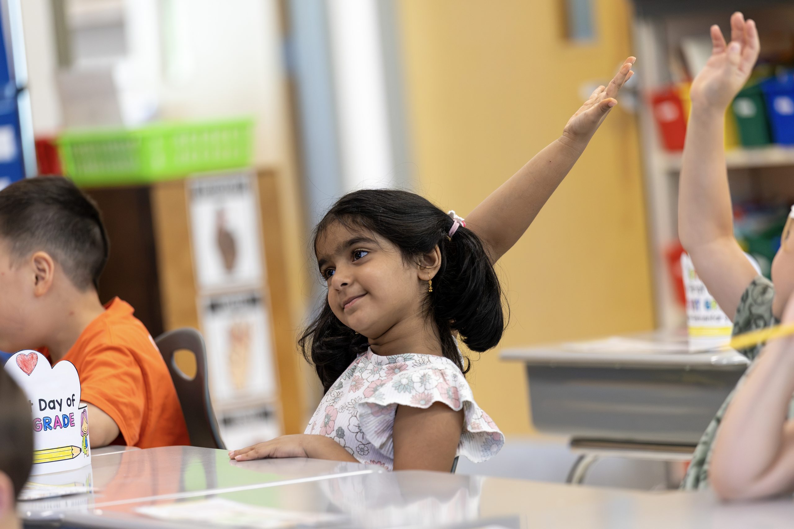 young kids raising their hands