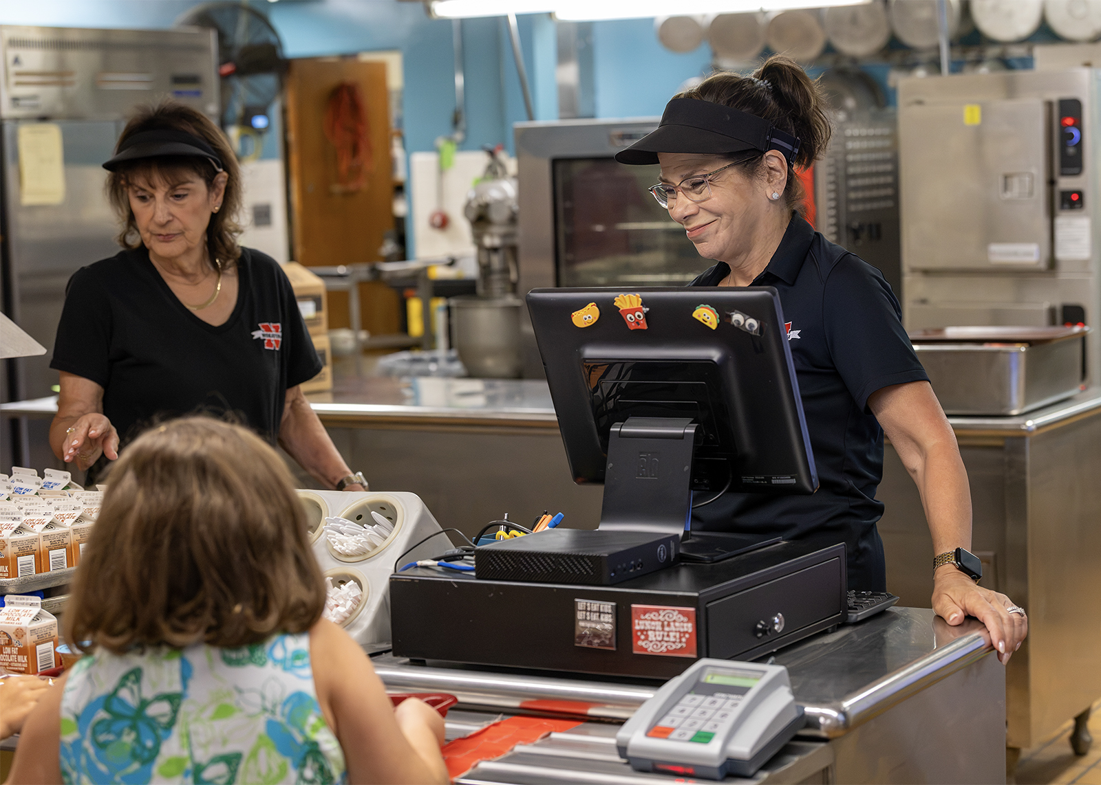 kitchen staff helping students in lunch line
