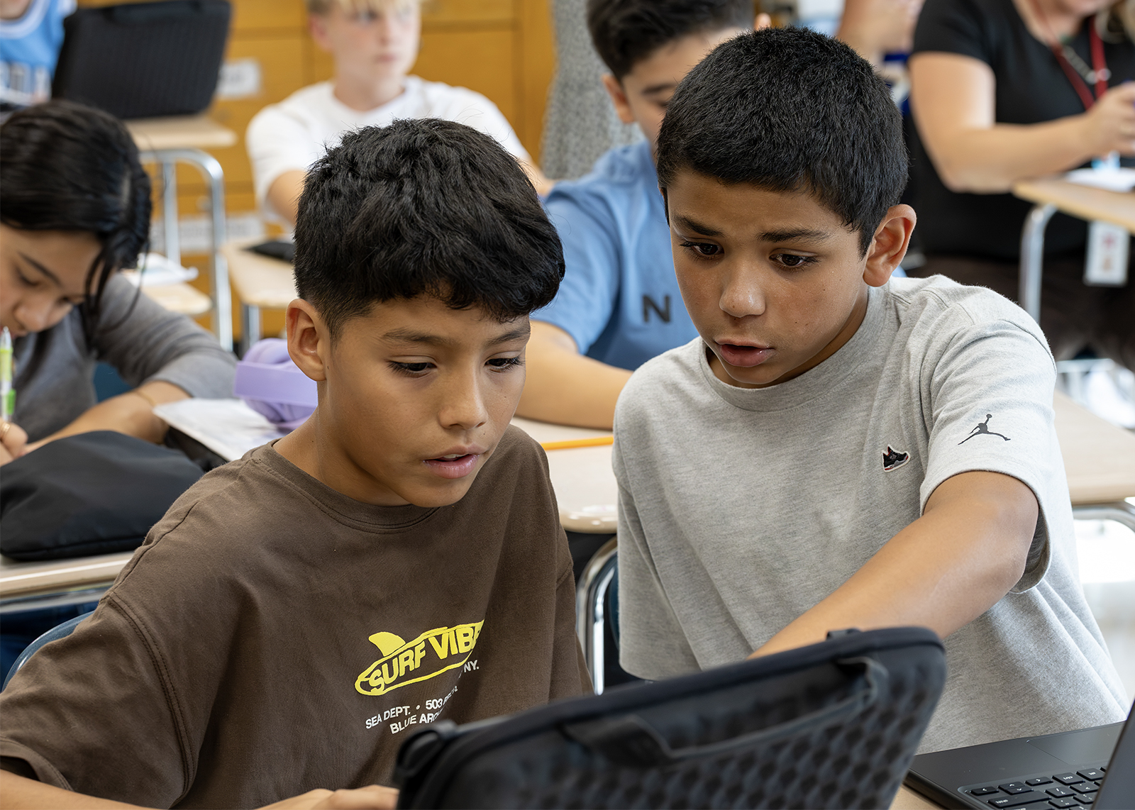 middle school students working on chromebook