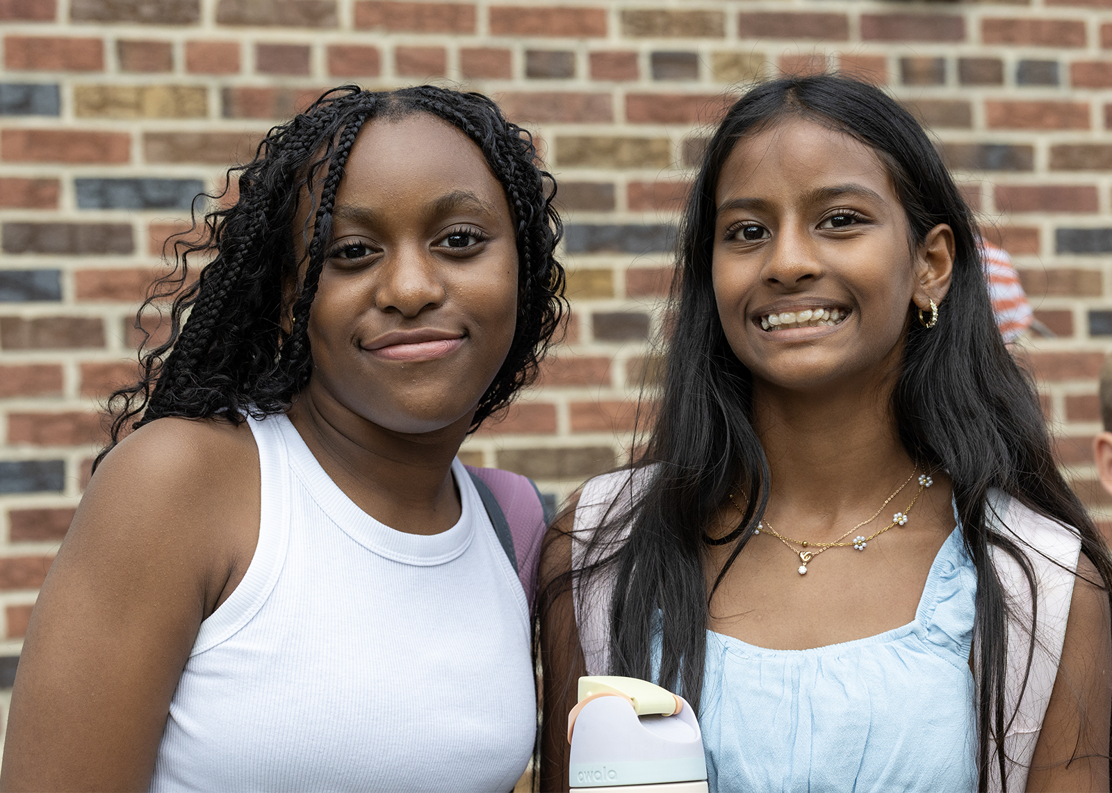 two middle schoolers smiling outside at end of day