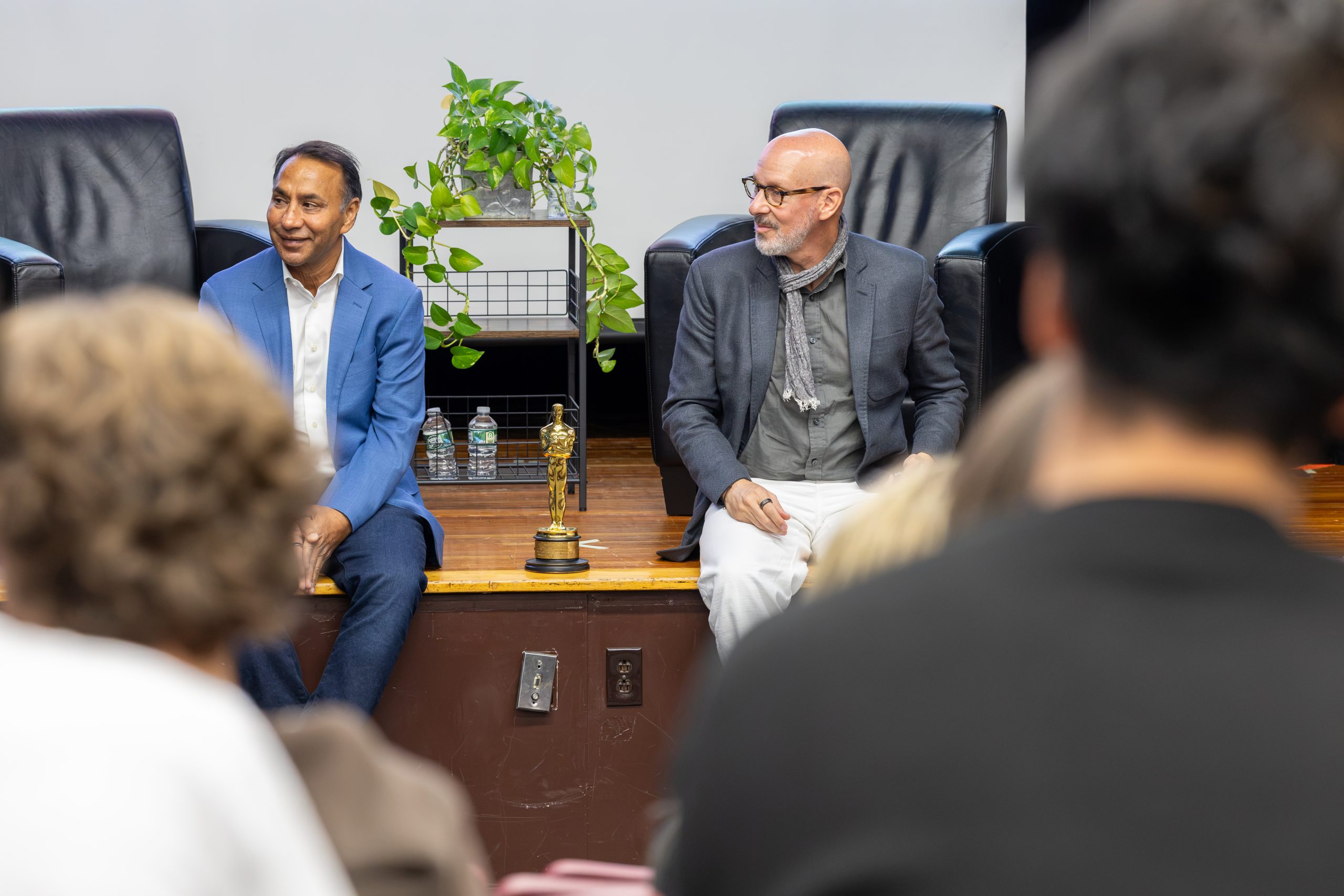 two individuals speak to students