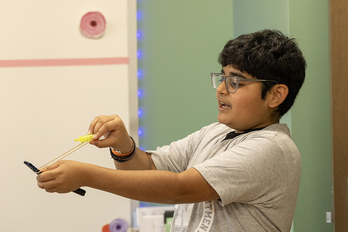 middle school student building with LEGO