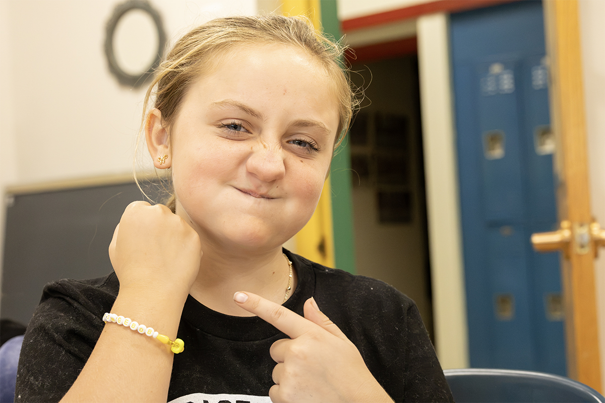middle school student showing off newly made bead bracelet 